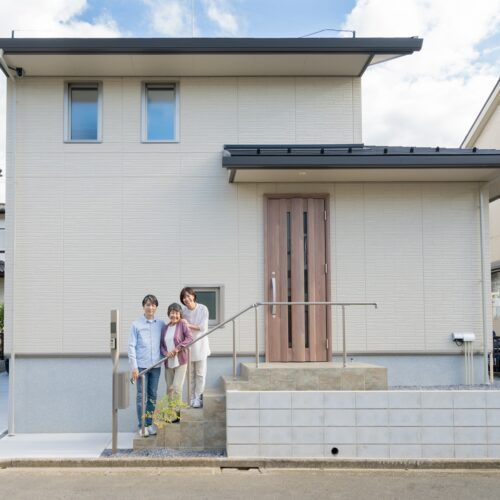 新築住宅の前で記念撮影する家族