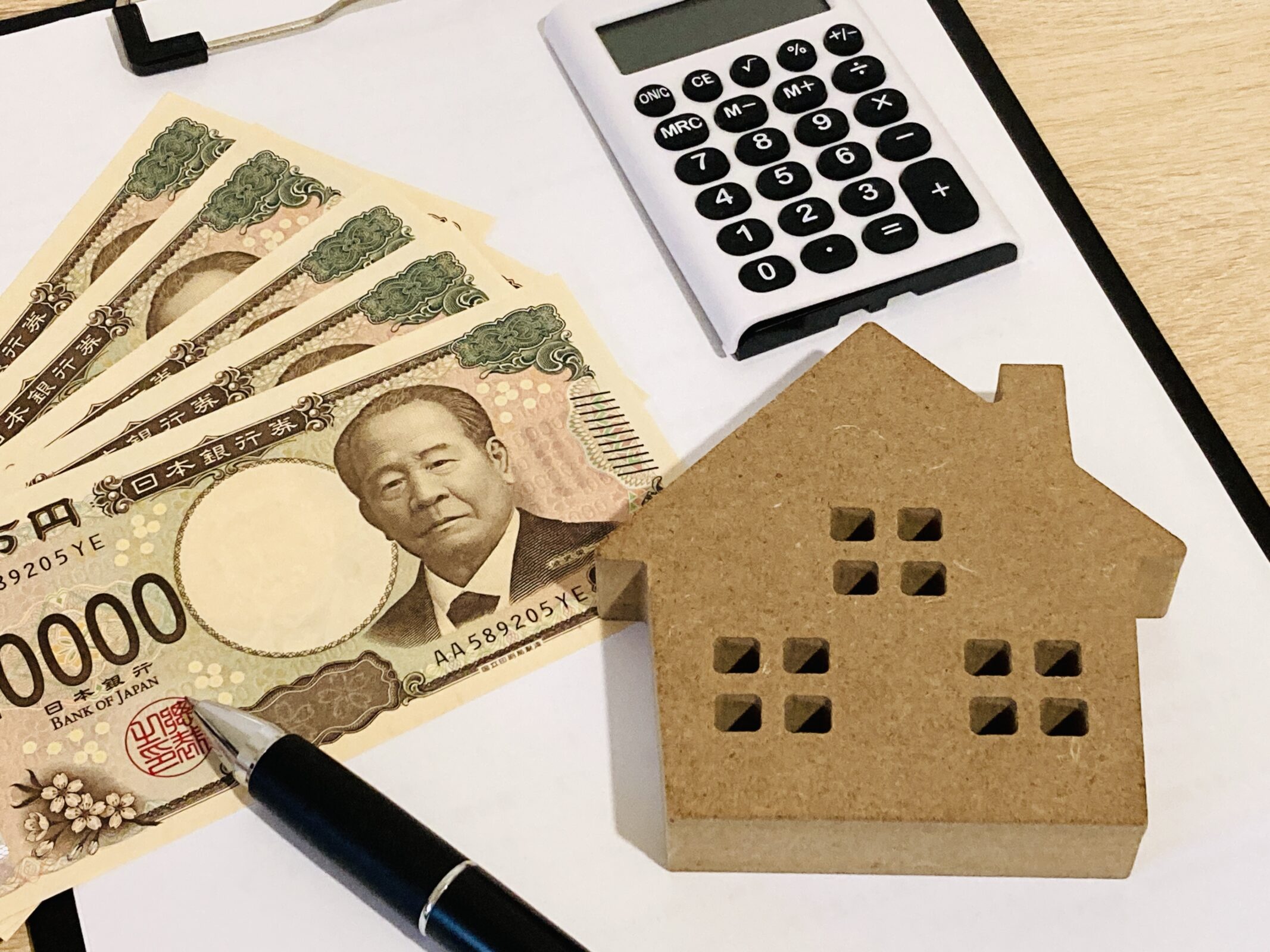 電卓と家の模型とお金。住宅購入やリノベーションにかかる費用、補助金イメージ